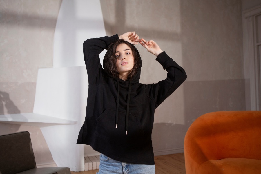 A person wearing the best oversized hoodies UK from The Reckless streetwear brand in an urban setting.